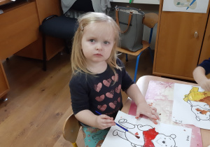 Ania maluje farbami kontury Misia Puchatka